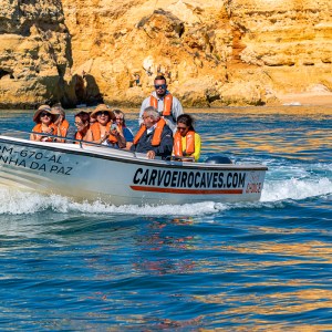 a group of people riding on the back of a boat in the water