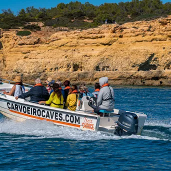 a group of people riding on the back of a boat in the water