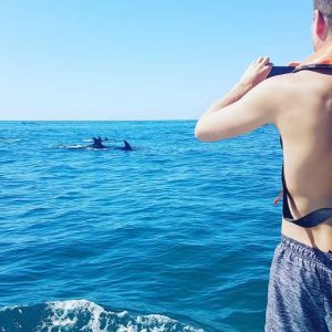 a woman standing next to a body of water